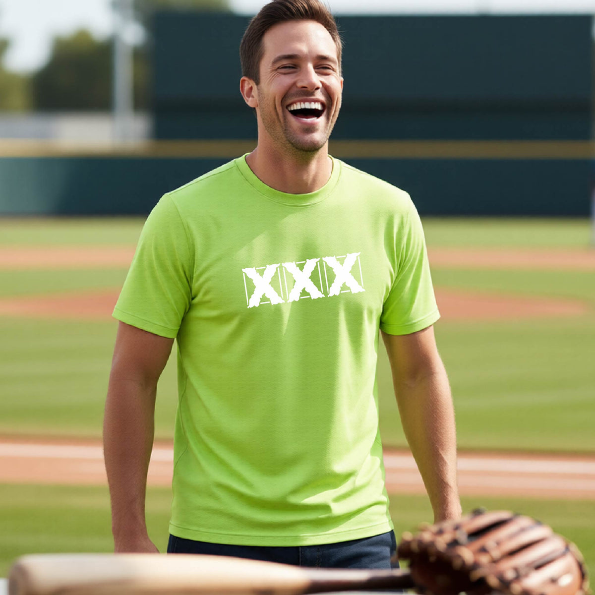 A man laughing on a baseball field wearing a bright lime green t-shirt with a white XXX graphic across the chest, holding a baseball glove in the foreground.