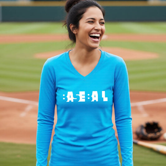 A smiling woman wearing a bright blue long-sleeve athletic shirt with the white text 'BASEBALL' in a cutout design printed across the chest, standing on a baseball field.