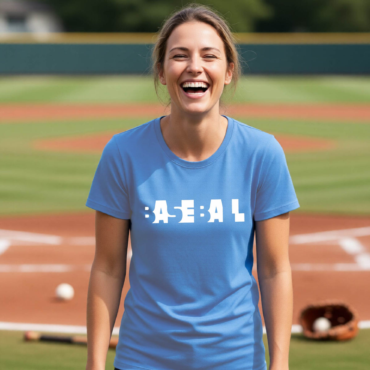 A smiling woman wearing a blue short-sleeve athletic shirt with the white text 'BASEBALL' in a cutout design printed across the chest, standing on a baseball field.