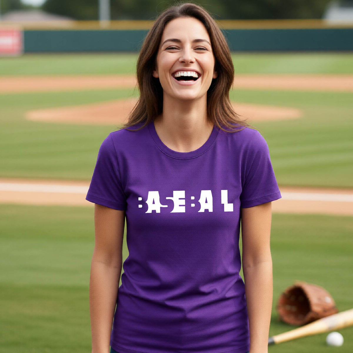 A smiling woman wearing a purple short-sleeve athletic shirt with the white text 'BASEBALL' in a cutout design printed across the chest, standing on a baseball field.