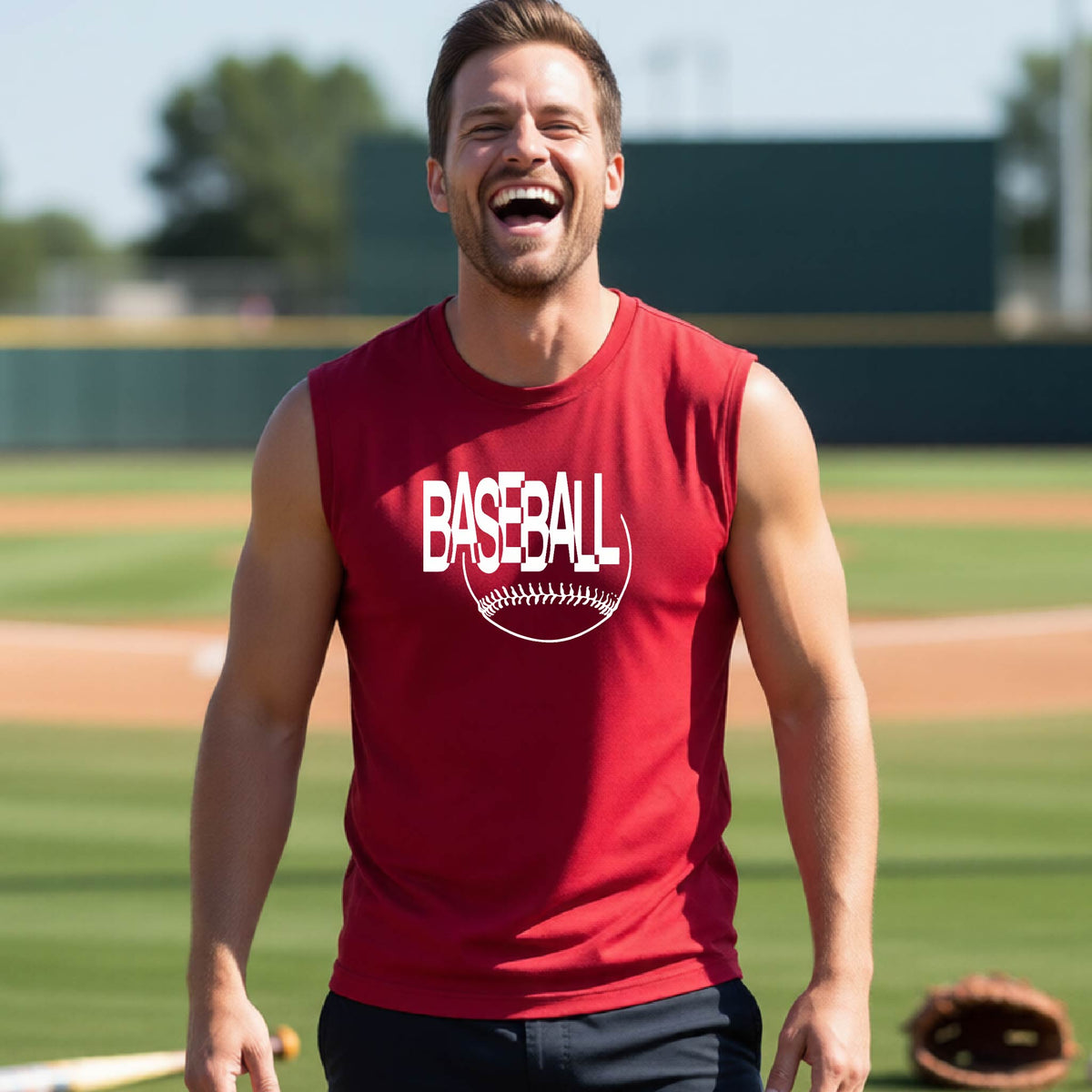 A man laughing on a baseball field wearing a red sleeveless t-shirt with a white 'BASEBALL' graphic and baseball stitching design on the front, standing on a baseball field.
