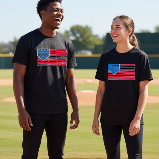Two young athletes wearing matching shirts smiling in front of a baseball diamond wearing black short-sleeve t-shirts with a colored graphic of an American flag using baseball bats and balls and a home plate, printed on the front.