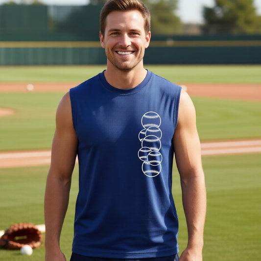 A man smiling in front of a baseball diamond wearing a royal blue sleeveless t-shirt, with a colorful graphic of a half baseball with a white graphic of 6 sketched baseballs overlapping, printed on the front of the shirt