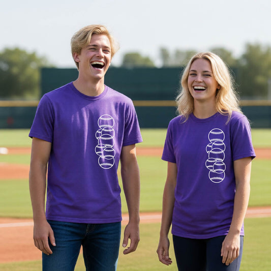 Two youth athletes wearing matching shirts, smiling in front of a baseball diamond wearing purple short-sleeve t-shirts, with a white graphic of 6 sketched baseballs overlapping, printed on the front of the shirt.