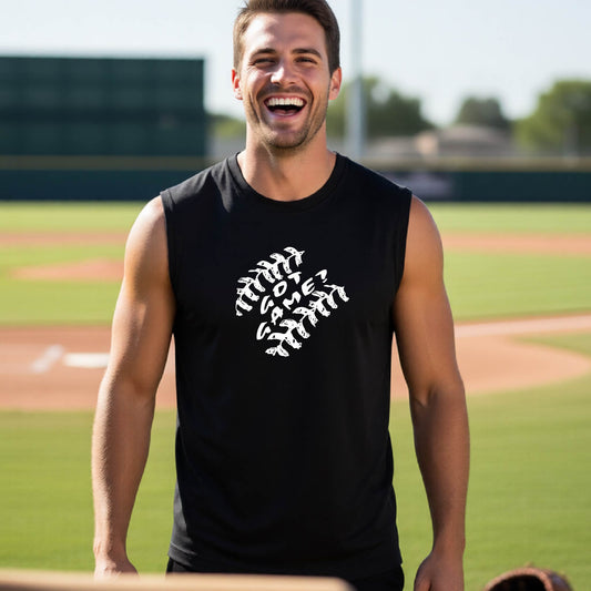 A man smiling in front of a baseball diamond wearing a black sleeveless t-shirt, with a white graphic of baseball stitches and the words ‘GOT GAME’ inside, printed on the front of the shirt.