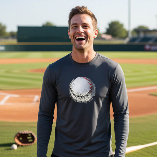 A man smiling in front of a baseball diamond wearing a dark gray long-sleeve t-shirt, with a white and red graphic of an outline of a sketched retro baseball, printed on the front.