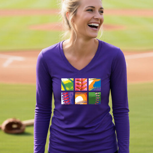 A woman smiling in front of a baseball diamond wearing a purple short-sleeve t-shirt, with a colorful graphic or 2x3 baseball squares of a baseball, printed on the front.