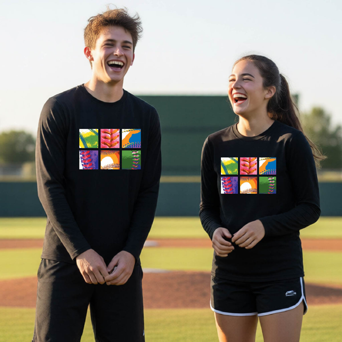 Two youth athletes wearing matching shirts, smiling in front of a baseball diamond wearing black long-sleeve t-shirts with a colorful grid graphic or 2x3 baseball squares of a baseball, printed on the front.