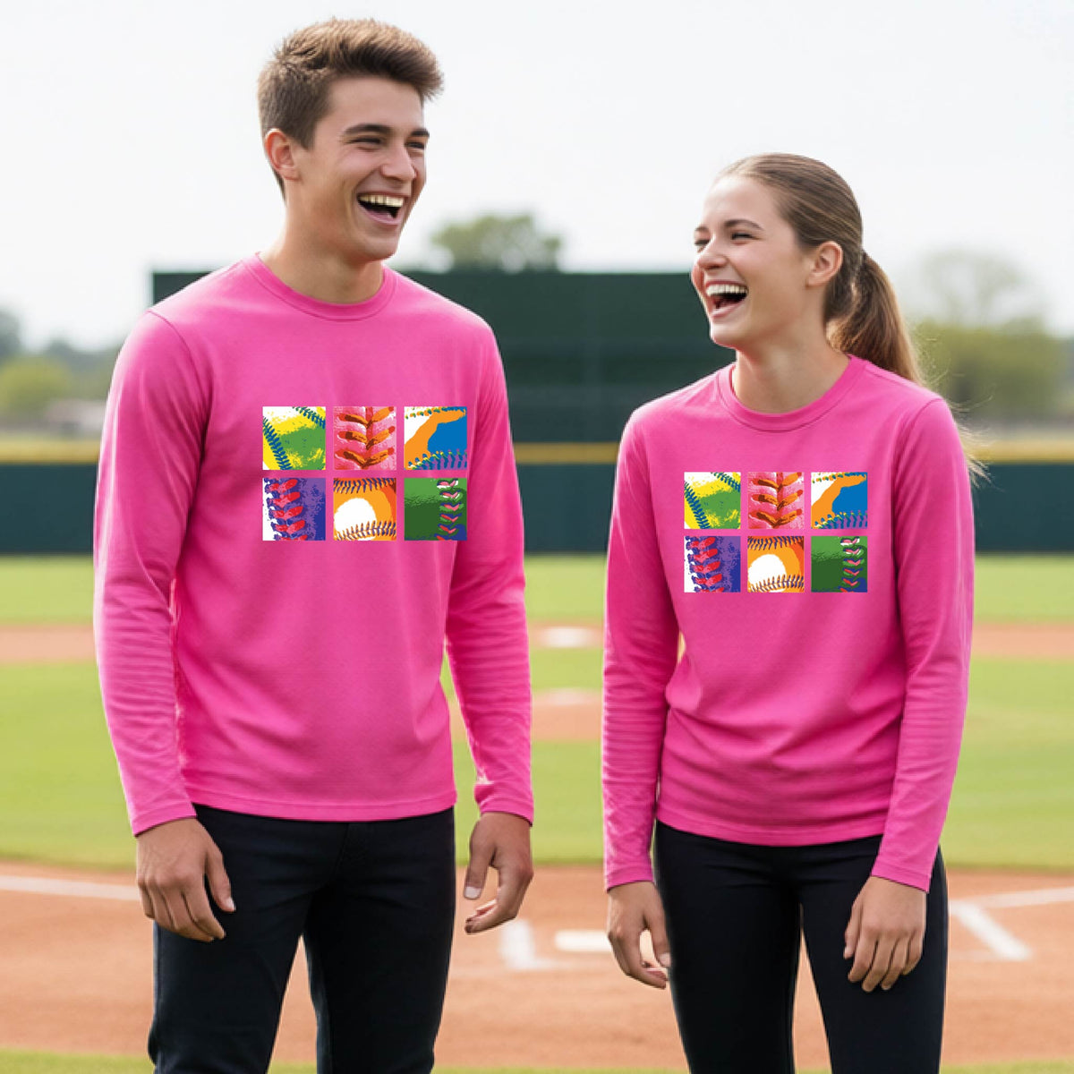 Two youth athletes wearing matching shirts, smiling in front of a baseball diamond wearing pink long-sleeve t-shirts with a colorful grid graphic or 2x3 baseball squares of a baseball, printed on the front.