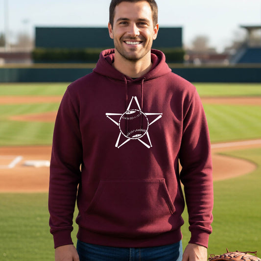 A man smiling in front of a baseball diamond wearing a maroon hoodie pullover, with a white graphic of a star made of baseball bats and a ball in the middle, printed on the front.