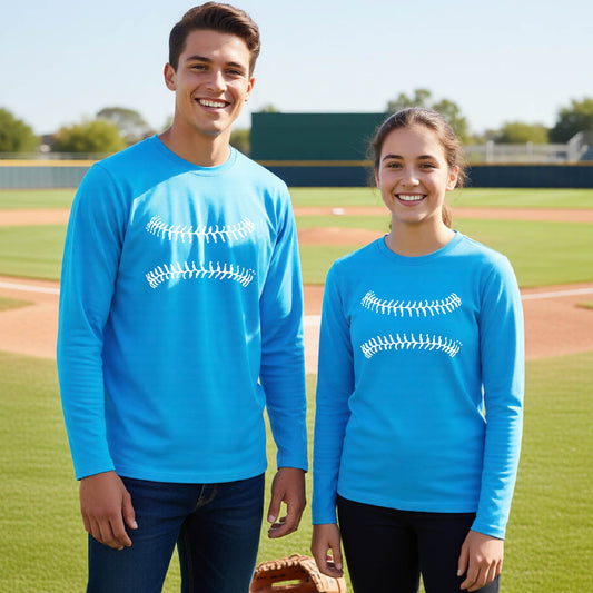 Two youth athletes wearing matching shirts, smiling in front of a baseball diamond wearing blue long-sleeve t-shirts with a white graphic of baseball stitches, printed on the front.