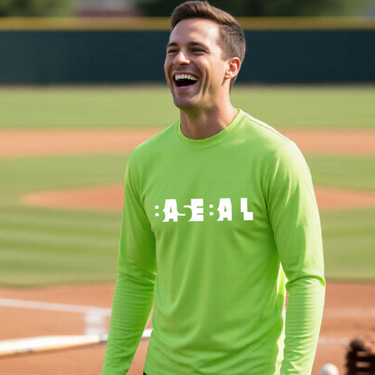 A smiling man wearing a lime green long-sleeve athletic shirt with the white text 'BASEBALL' in a cutout design printed across the chest, standing on a baseball field.