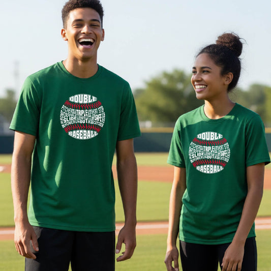 A man smiling in front of a baseball diamond wearing a green short-sleeve t-shirt, with a white and red graphic of a baseball made up of baseball words, printed on the front of the shirt.