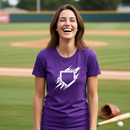 A woman smiling in front of a baseball diamond wearing a purple short-sleeve t-shirt, with an artistic white graphic of a sketch of baseball home plate, printed on the front of the shirt.