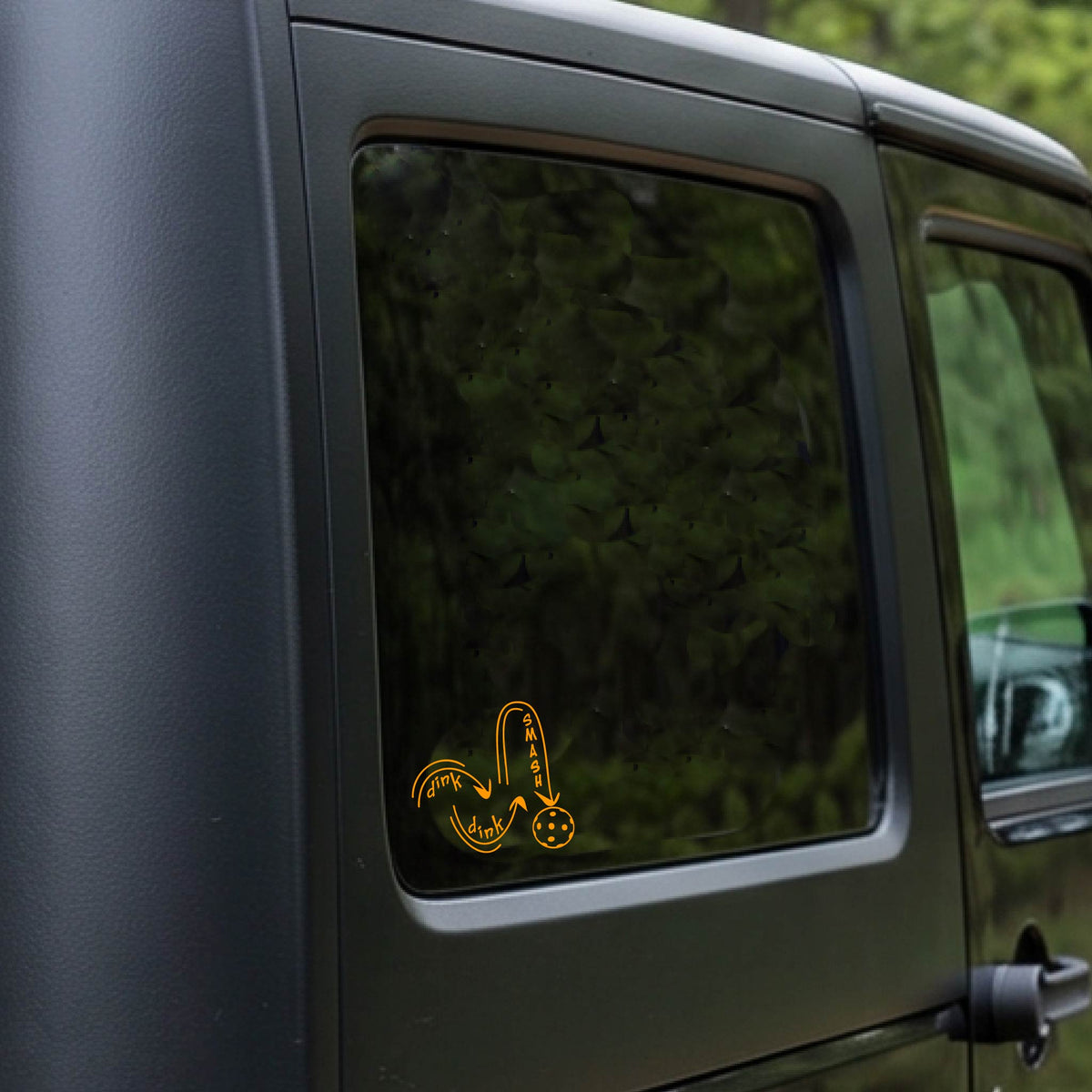 An orange vinyl decal of a pickelball logo' DINK DINK SMASH' an a yellow pickleball, applied a vehicle window. 