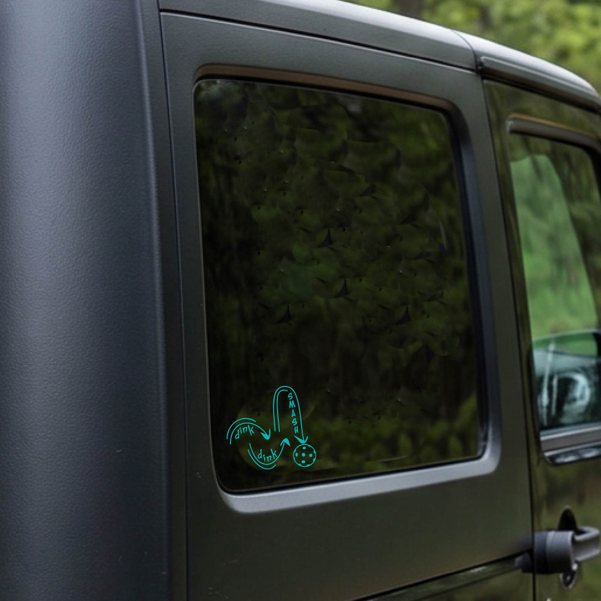 A turquoise vinyl decal of a pickelball logo' DINK DINK SMASH' an a yellow pickleball, applied a vehicle window. 