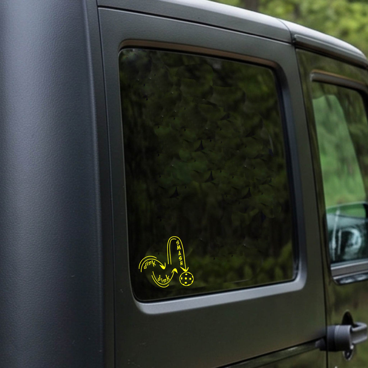A yellow vinyl decal of a pickelball logo' DINK DINK SMASH' an a yellow pickleball, applied a vehicle window. 