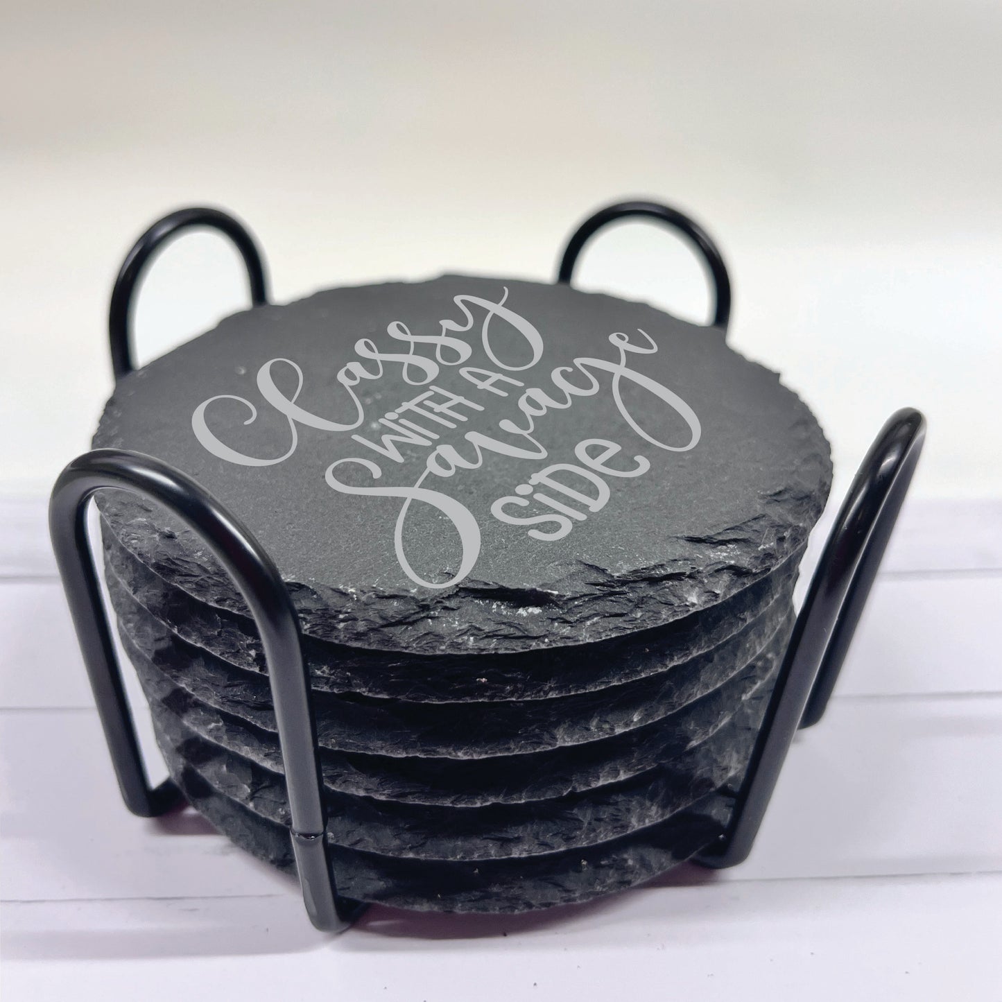 Set of slate coasters with a holder on a white background