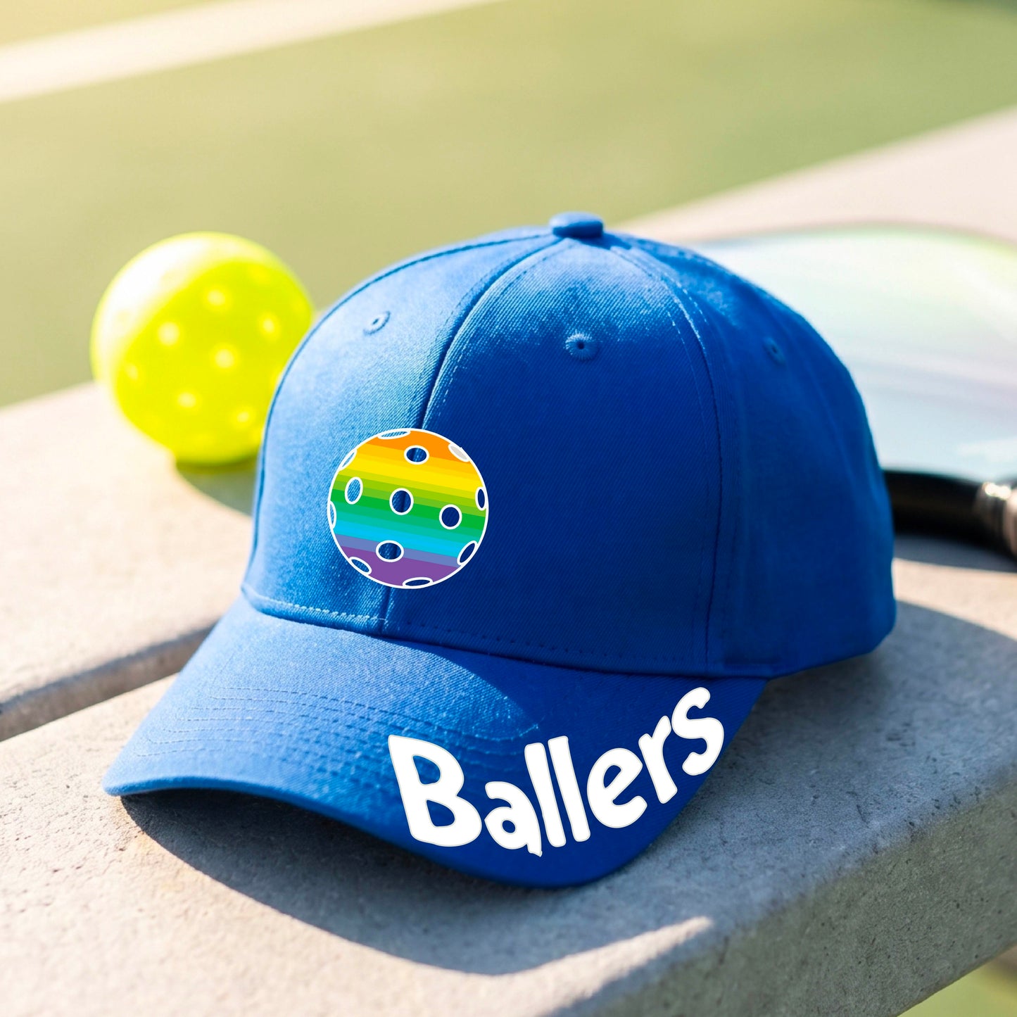 A close up of a royal blue  baseball cap with a pickleall graphic on the front and the word 'Ballers' in white on the brim.