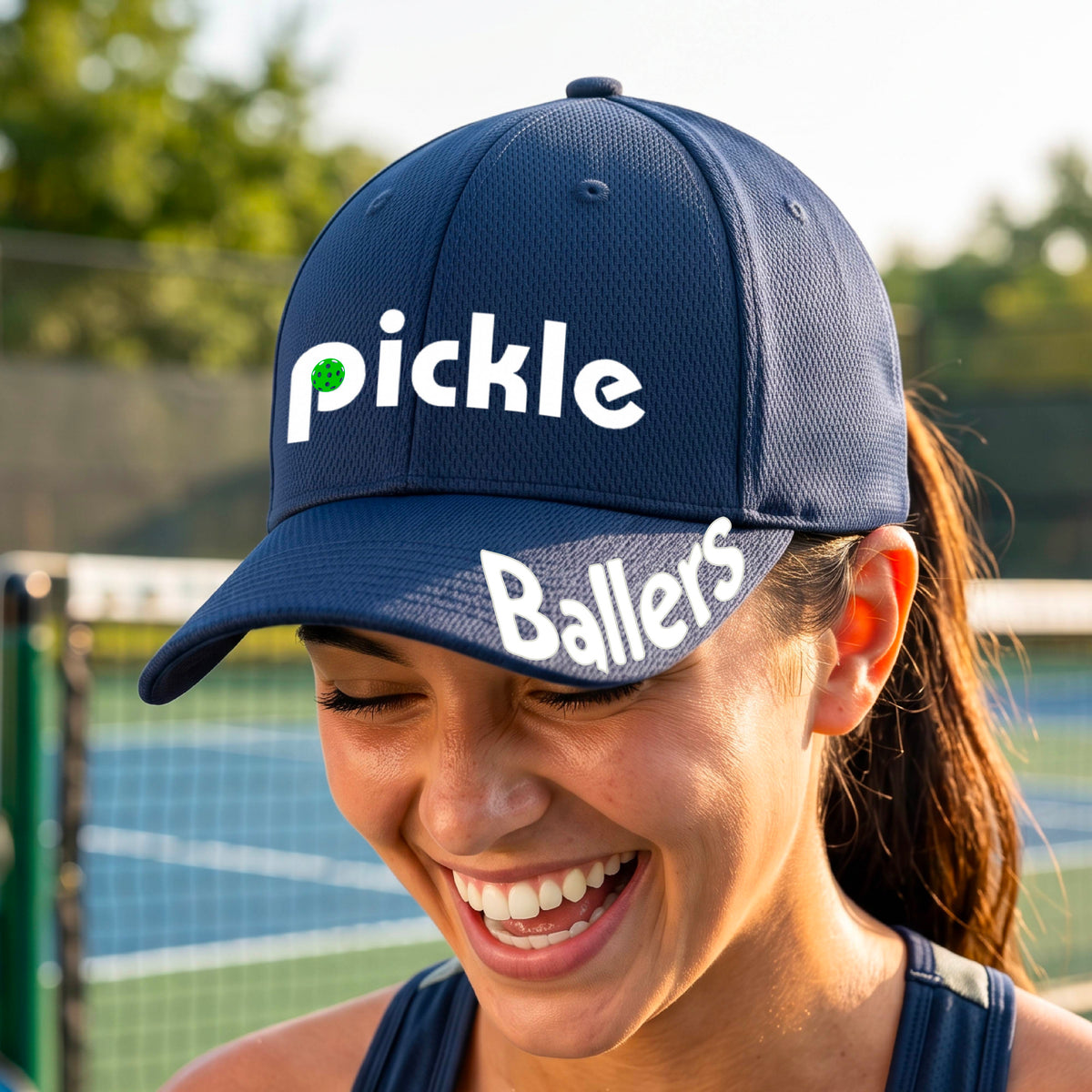 A close up of a navy blue mid-profile pickleball baseball cap with the text 'pickle' across the front and 'ballers' curved on the brim. 