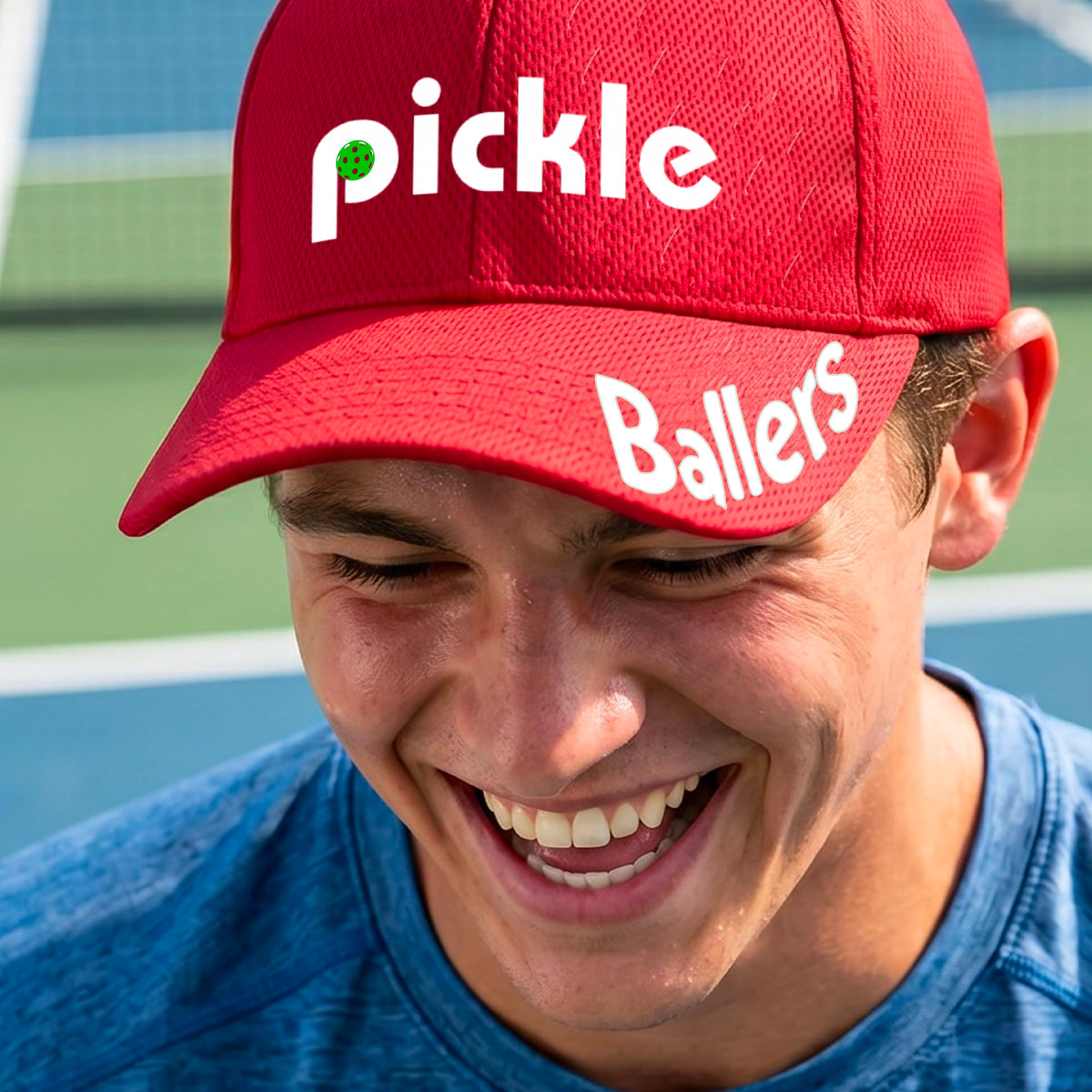 A close up of a red mid-profile pickleball baseball cap with the text 'pickle' across the front and 'ballers' curved on the brim. 