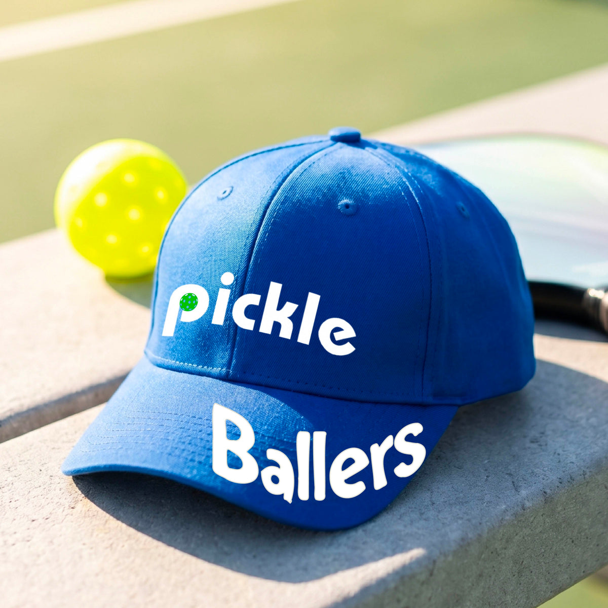 A close up of a royal blue mid-profile pickleball baseball cap with the text 'pickle' across the front and 'ballers' curved on the brim. 