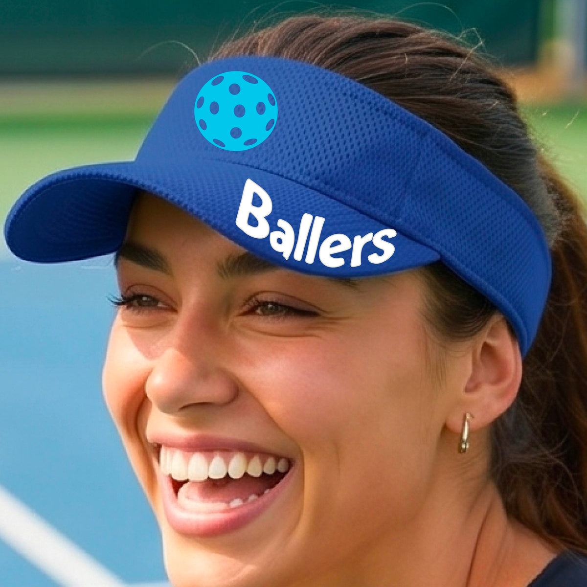 A person wearing a royal blue visor with a yellow pickleball graphic and the word 'Ballers' in white,.