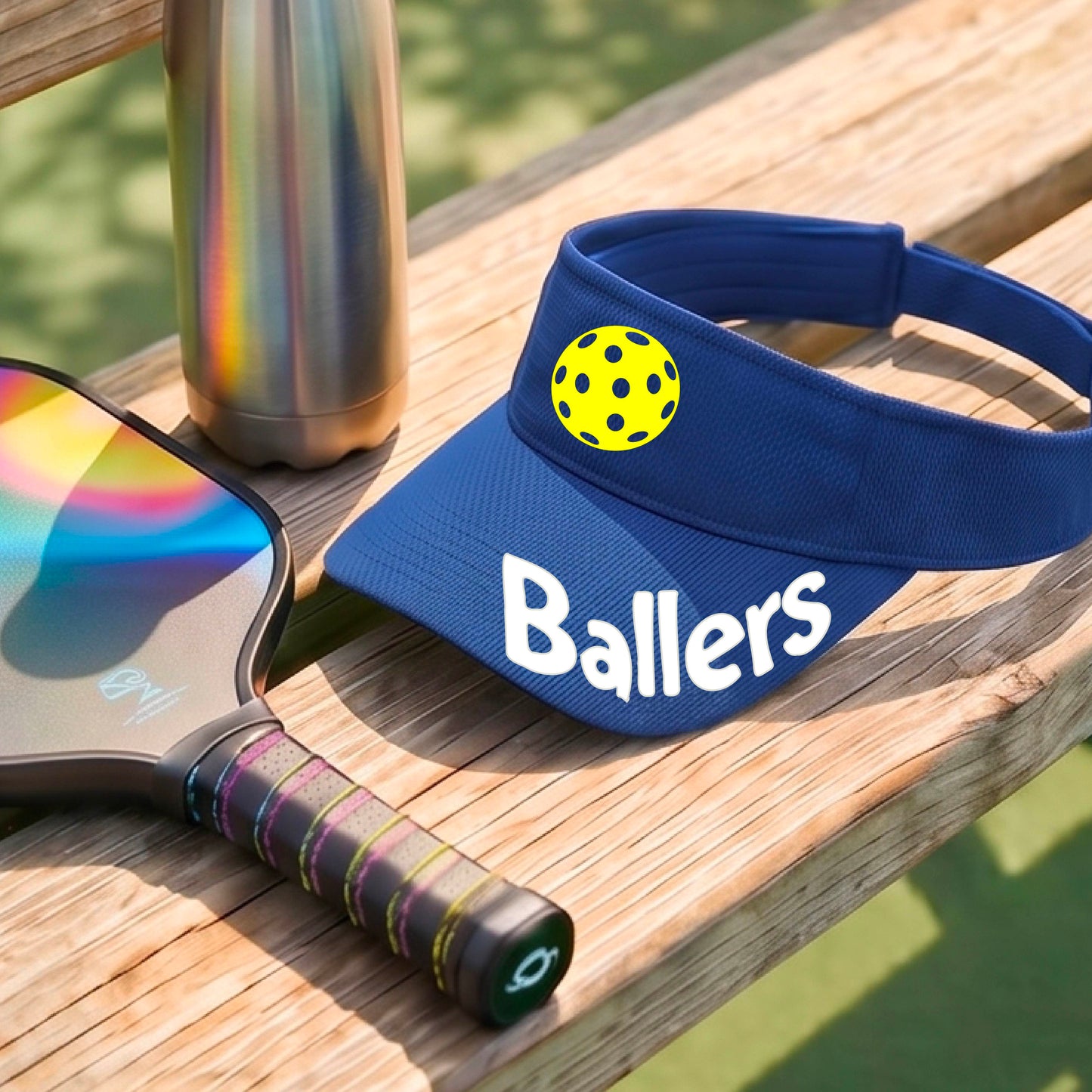 A close up of a royal blue visor with pickleball graphic and the word 'Ballers' in white,.