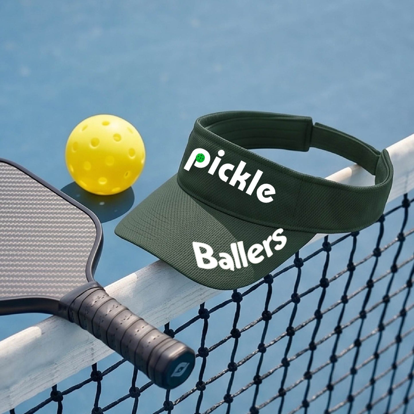 A close up of a green visor with a pickleball graphic of 'pickle' and 'Ballers' printed in white on the front and brim.