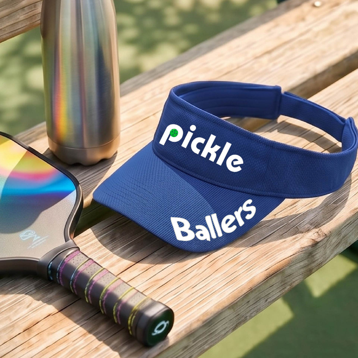 A close up of a royal blue visor with a pickleball graphic of 'pickle' and 'Ballers' printed in white on the front and brim.