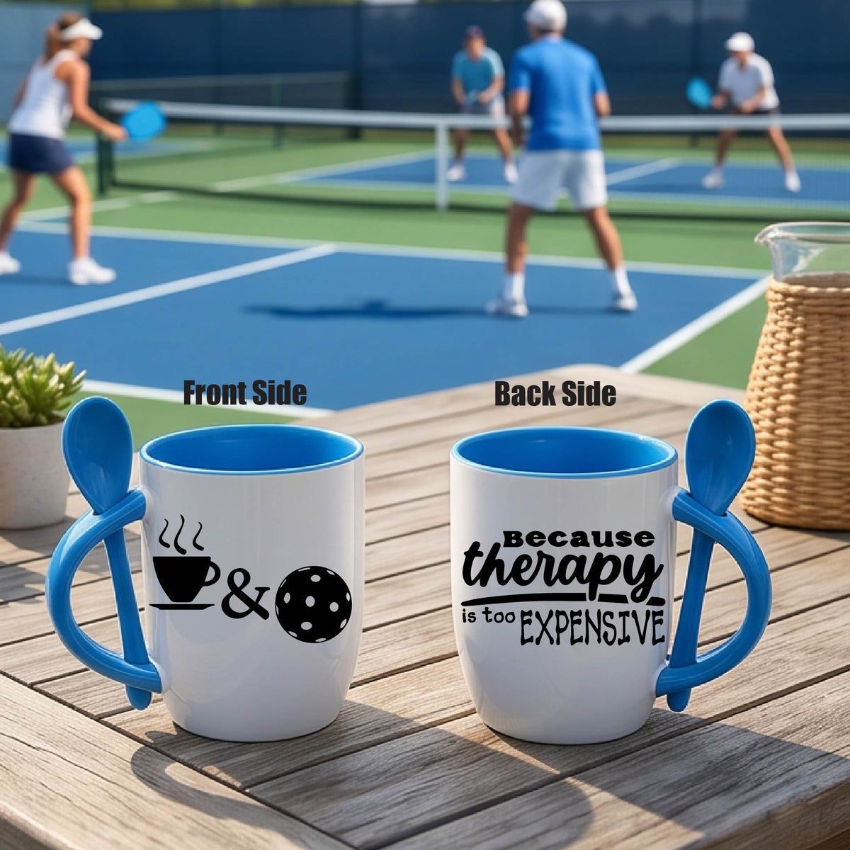 Alt Text:
a white and blue 12 ounce coffee mug with a built in spoon in the handle with and a fun coffee cup pickleball graphic and wraparound text 'BECAUSE THERAPY IS TOO EXPENSIVE" 
