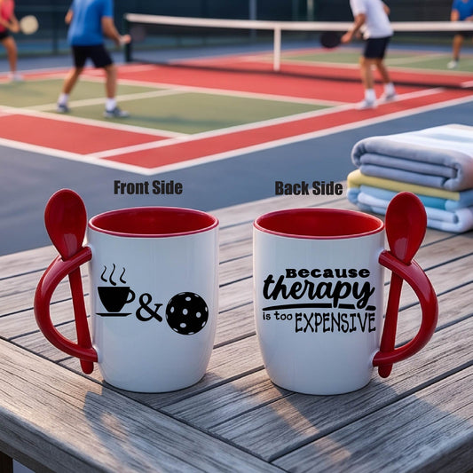 Alt Text:
a white and RED 12 ounce coffee mug with a built in spoon in the handle with and a fun coffee cup pickleball graphic and wraparound text 'BECAUSE THERAPY IS TOO EXPENSIVE" 
