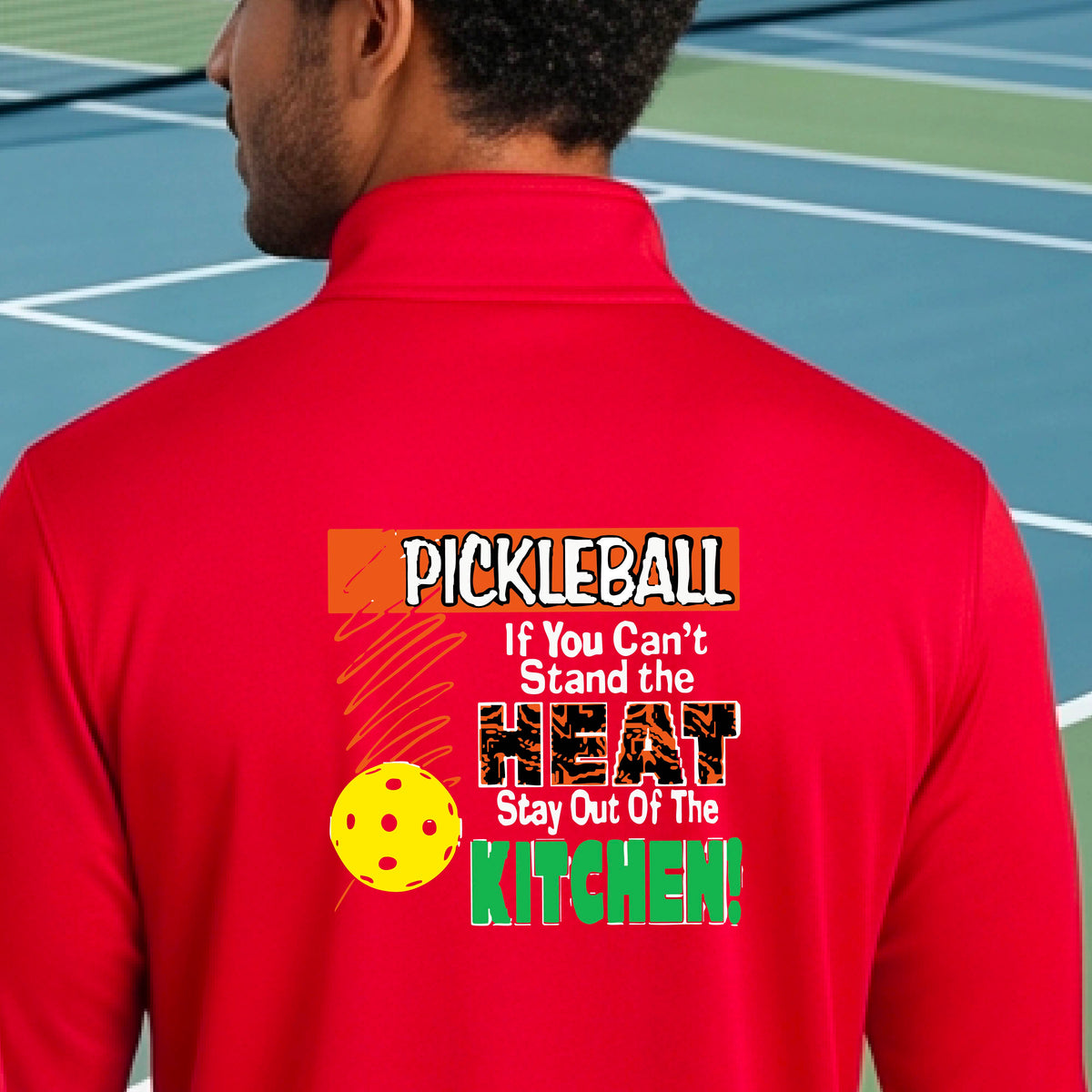 A man viewed from behind wearing a red long-sleeve quarter-zip pullover with a colorful pickleball-themed graphic on the back. The graphic features the word 'PICKLEBALL' in orange, a yellow pickleball, and the text 'If You Can't Stand the HEAT Stay Out Of The KITCHEN!' in white and green.