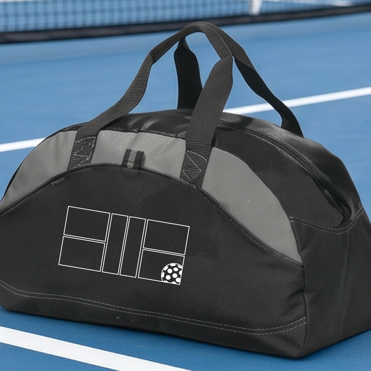 A close up of a gray and black pickleball duffel bag with a white pickleball court and ball graphic.