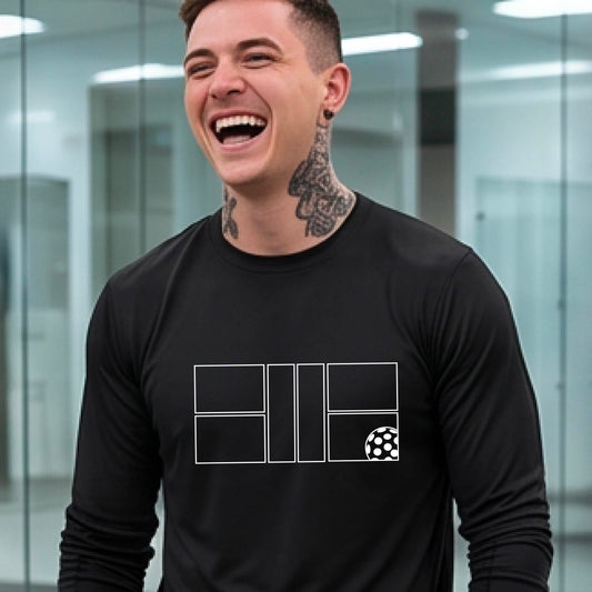 A smiling man wearing a black long-sleeve athletic shirt with a white geometric pickleball court and ball graphic on the chest,.