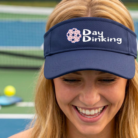 A close up of a navy blue visor with a white 'Day Dinking' graphic with a colorful pickleball icon.