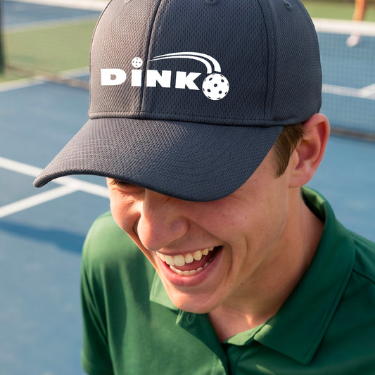 A close-up of a person wearing a gray baseball cap with a white 'DINK' logo and pickleball graphic on the front.