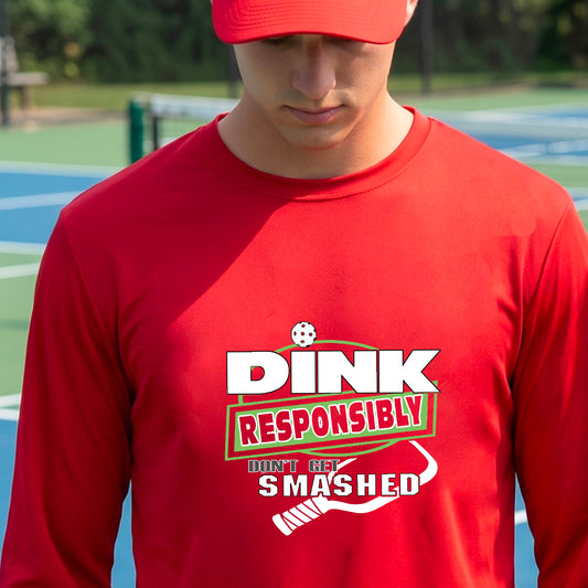 A man wearing a bright red long-sleeve t-shirt with a 'DINK RESPONSIBLY DON'T LET SMASHED' graphic on the front, and a pickelball paddle graphic.