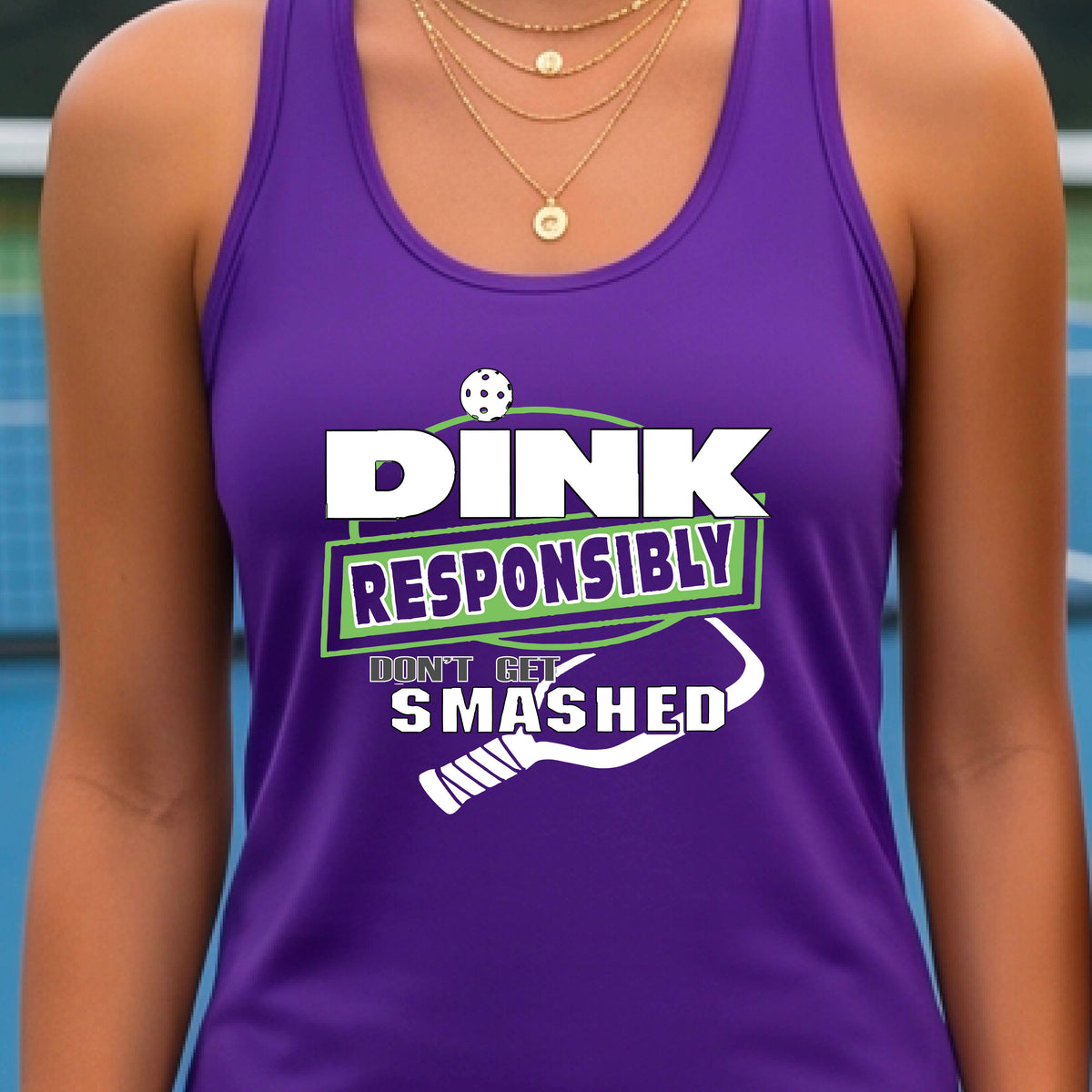  A woman wearing a purple racerback tank top with a white and light green graphic that reads 'DINK RESPONSIBLY DON'T GET SMASHED' with a pickleball paddle graphic. 