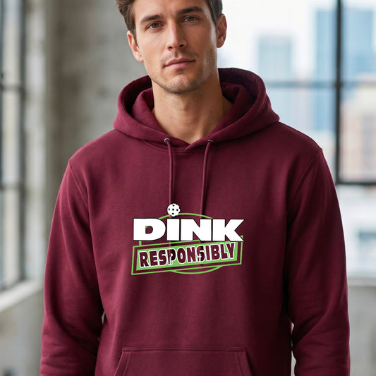 A man wearing a pickleball maroon pullover hoodie with a graphic on the chest that reads 'DINK RESPONSIBLY' in white and green.