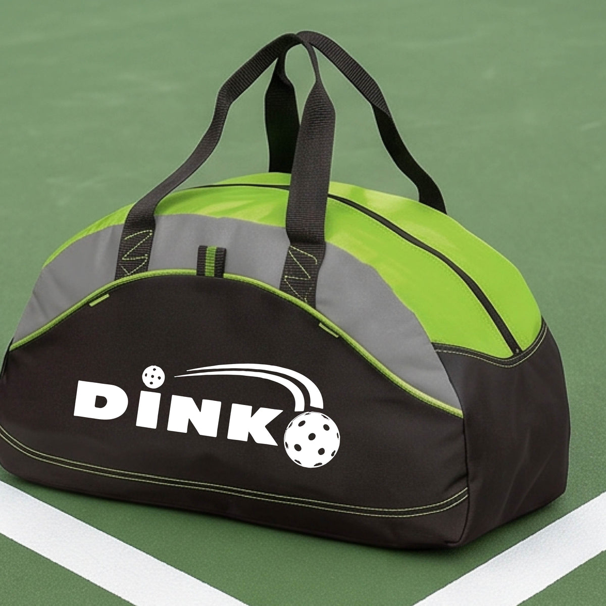 A close up of a lime green, black and gray pickleball  duffel bag with a pickleball design of text 'DINK' with a white pickleall in flight, on a pickleball court .