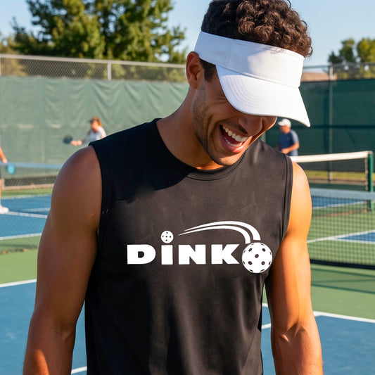 A man wearing a black sleeveless t-shirt with a pickleball design of text 'DINK' with a white pickleall in flight, standing on a pickleball court.