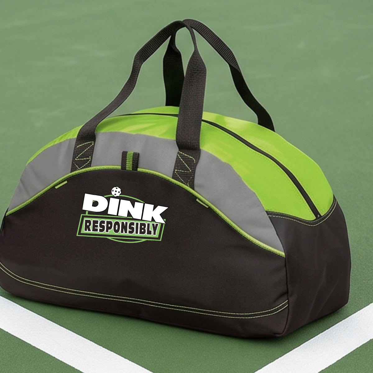 A lime green, black, and gray duffel bag with custom 'DINK RESPONSIBLY' branding, placed on a pickleball court with a blue court visible in the background.
