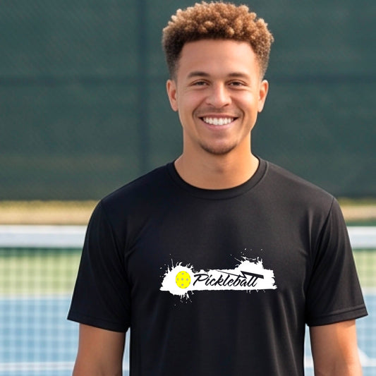 A smiling man wearing a black t-shirt with a 'Pickleball' splatter graphic on the chest, 