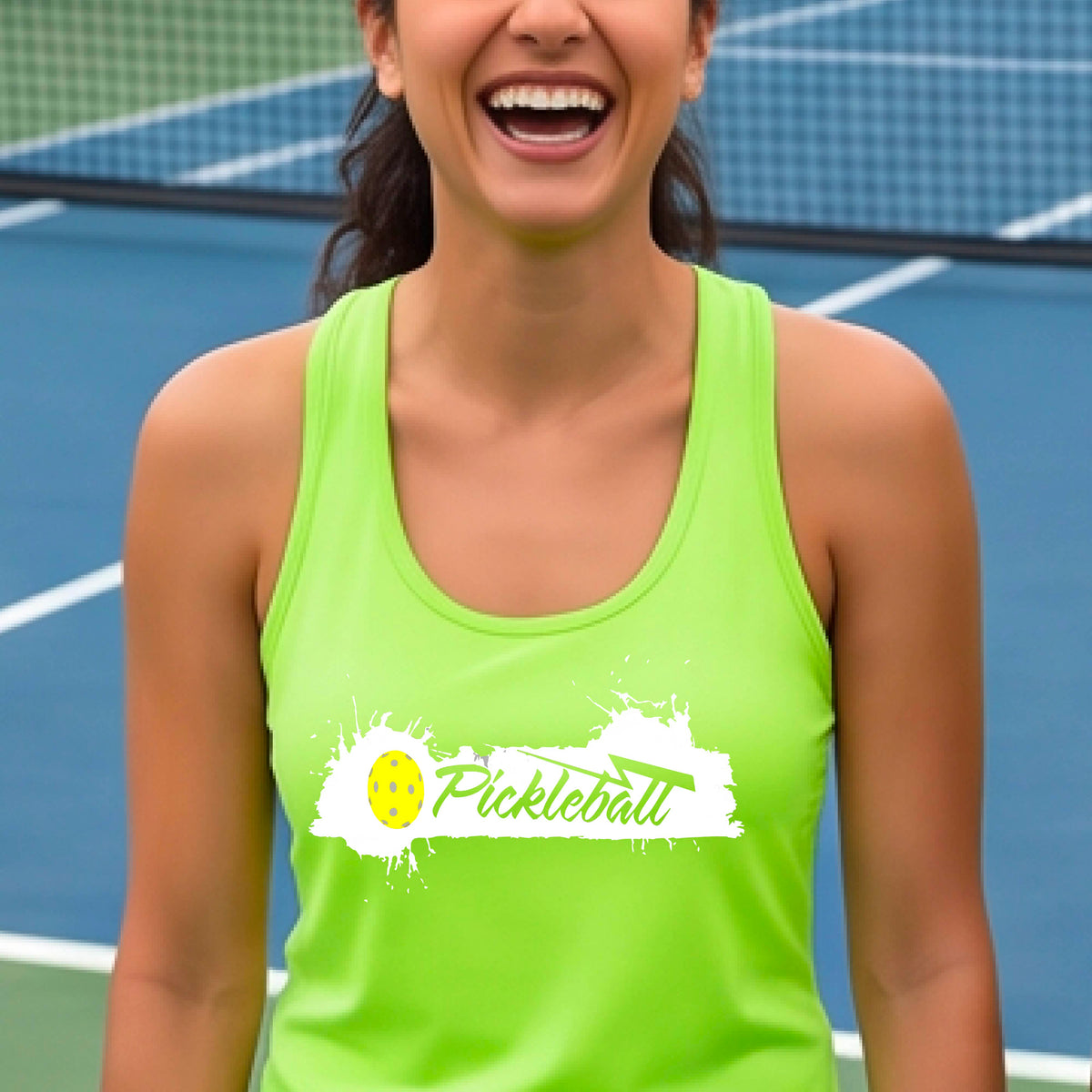A smiling woman on a pickleball court wearing a lime green racerback athletic tank top with a white and yellow 'Pickleball' graphic on the front.