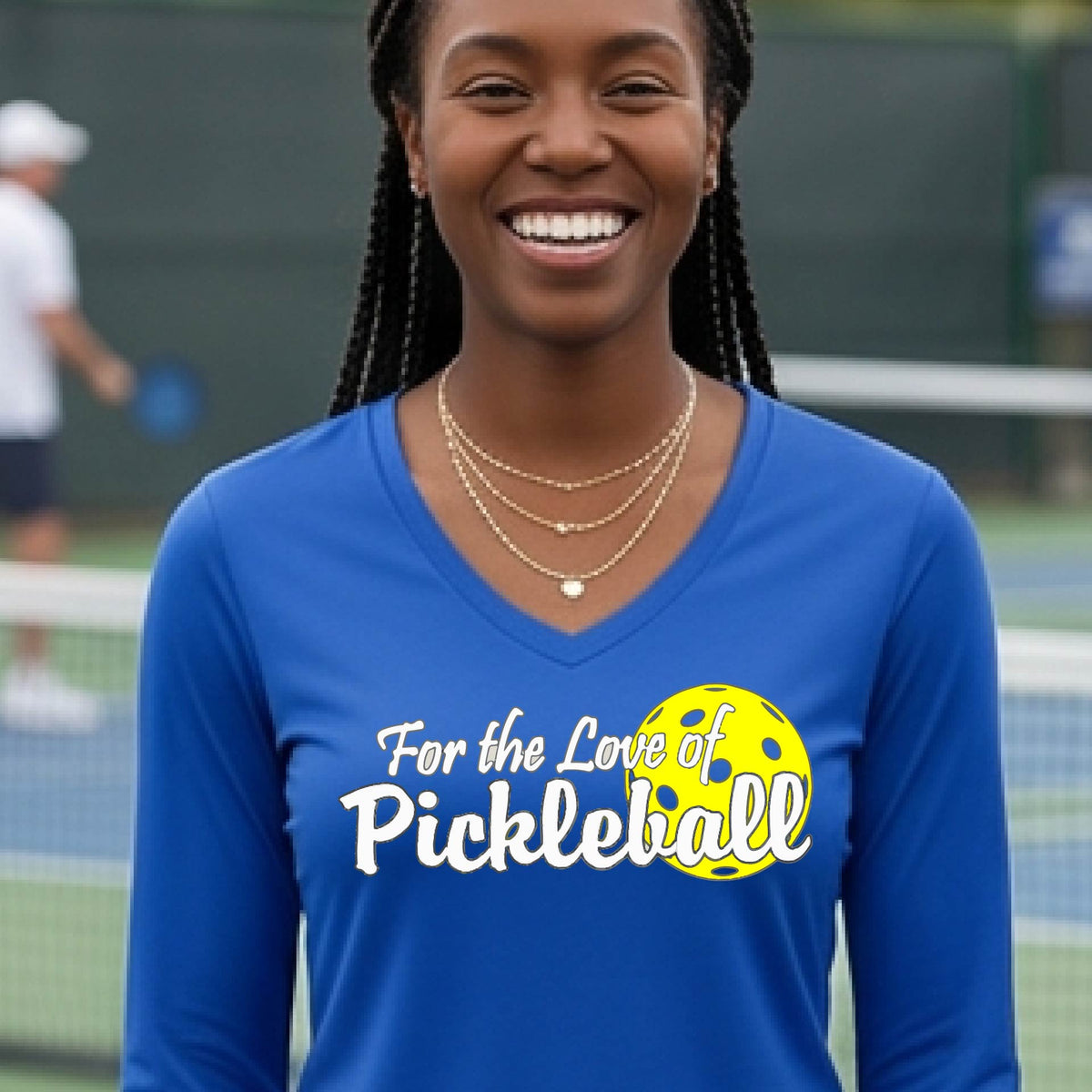 A close-up of a womens royal blue long-sleeve v-neck t-shirt with a pickleball graphic of ‘FOR THE LOVE OF PICKLEBALL’ in white with a yellow pickleball behind it graphic on the front.