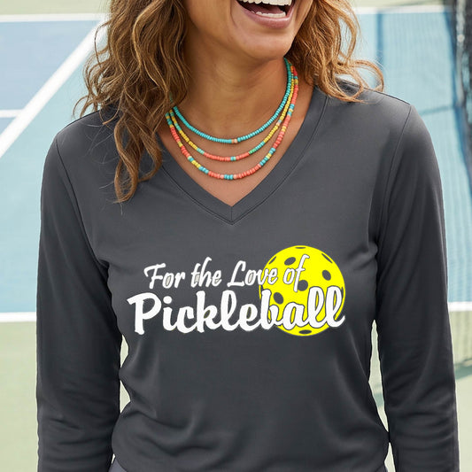A close-up of a womens dark gray long-sleeve v-neck t-shirt with a pickleball graphic of ‘FOR THE LOVE OF PICKLEBALL’ in white with a yellow pickleball behind it graphic on the front.