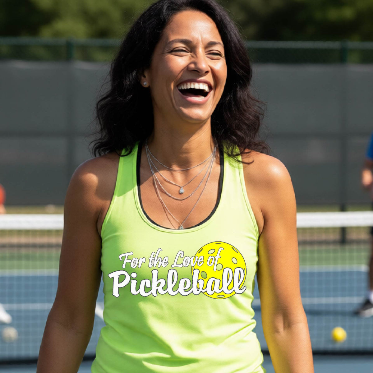 A close-up of a lime green womens racerback tank with a pickleball graphic of ‘FOR THE LOVE OF PICKLEBALL’ in white with a yellow pickleball behind it graphic on the front.