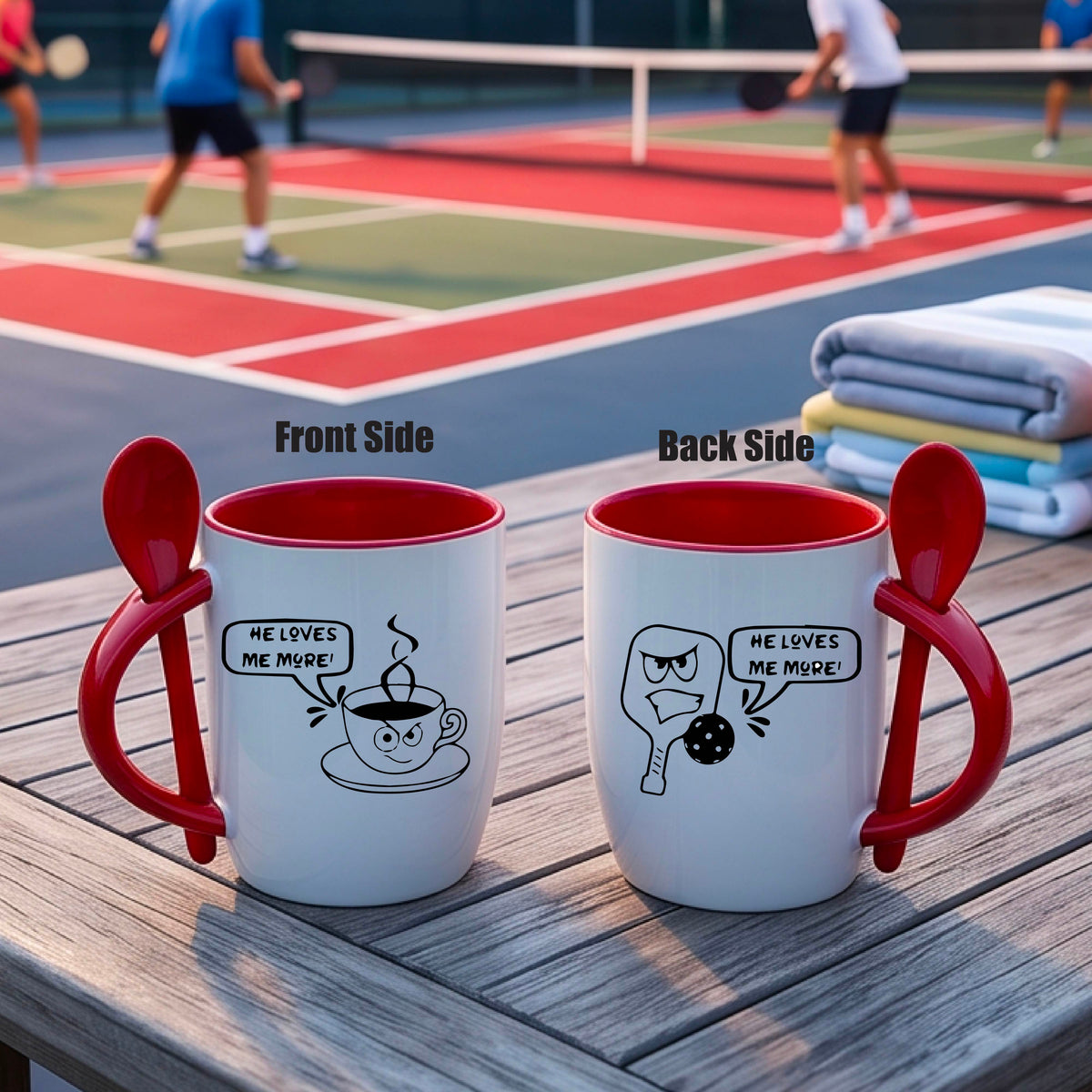 A white and red 12 ounce coffee mug with a built in spoon in the handle with and a fun pickleball paddle and ball and coffee cup graphic and the text “HE LOVES ME MORE”