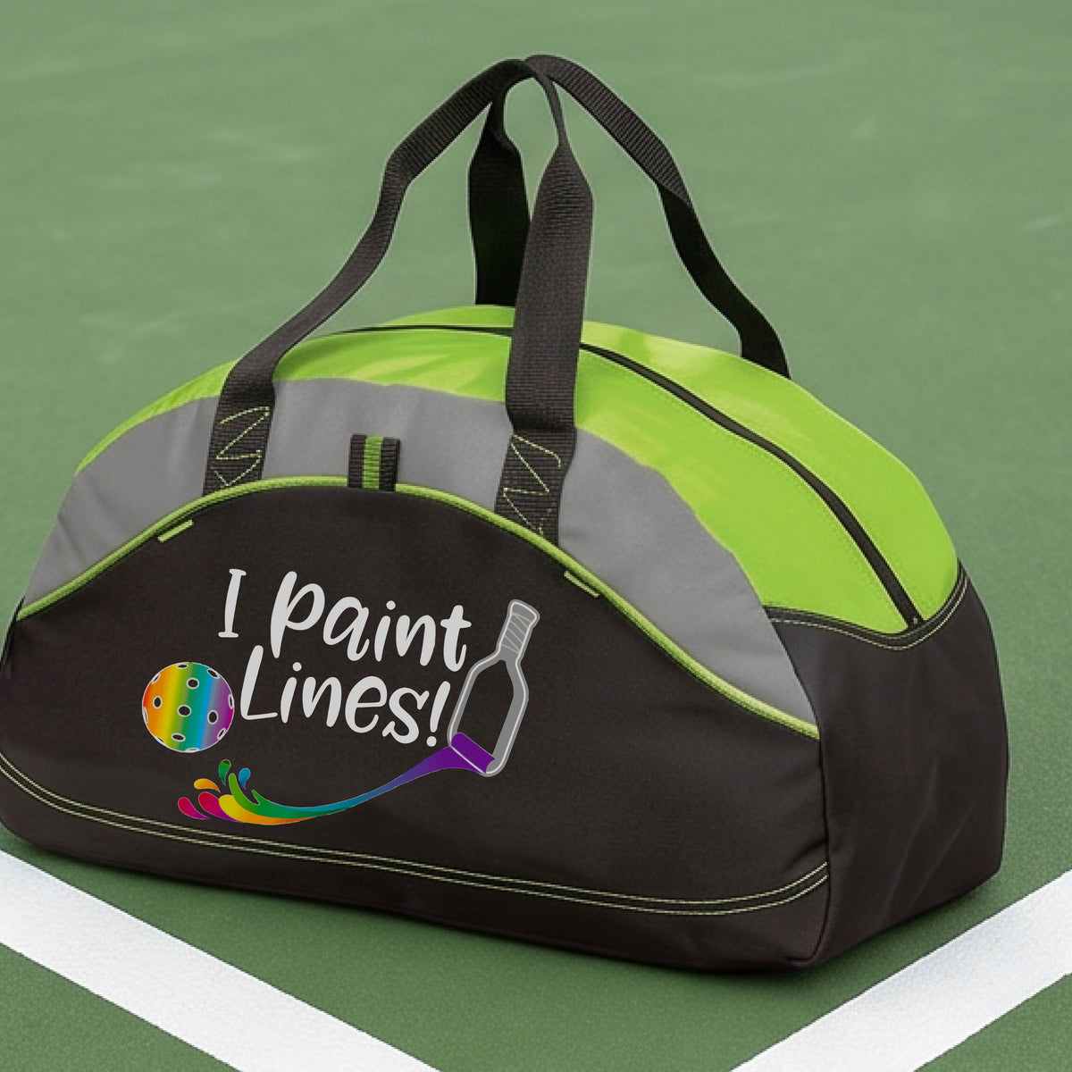 A close-up of green,  gray and black medium size duffel bag with a graphic on the front that has white text "I PAINT LINES'  with a white pickleball paddle painting multi-colored lines leading a mutli-colored pickleball.